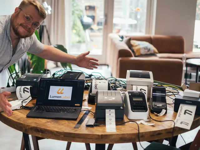 Koert at the dining table full of label printers, laptop open with LumenLabel
