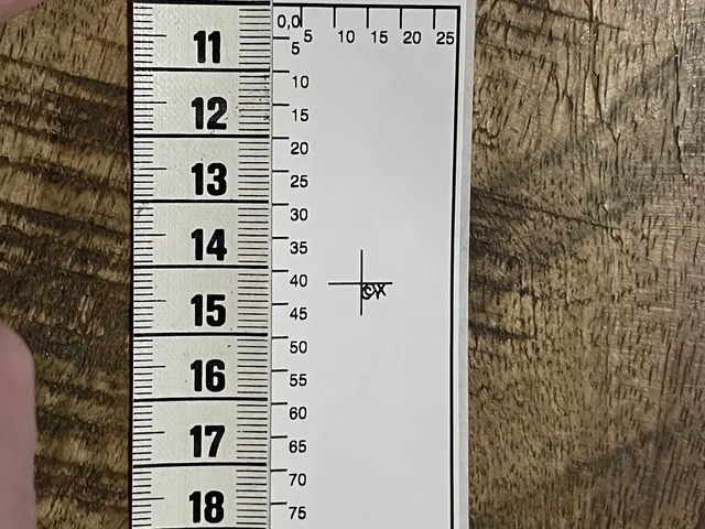 Printed test label with a millimetre scale, measured against a tape measure